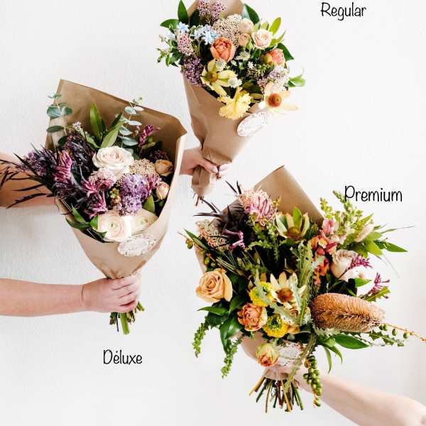 Three wrapped bouquets of mixed flowers in different sizes