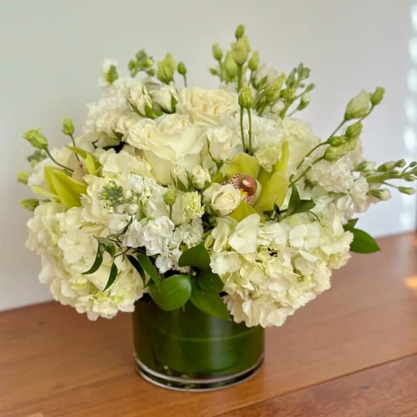 White floral arrangement in a green glass vase