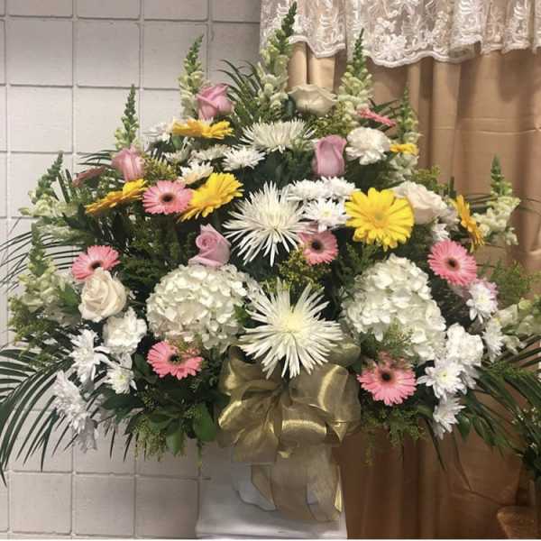 Large standing floral spray with white, pink, and yellow flowers