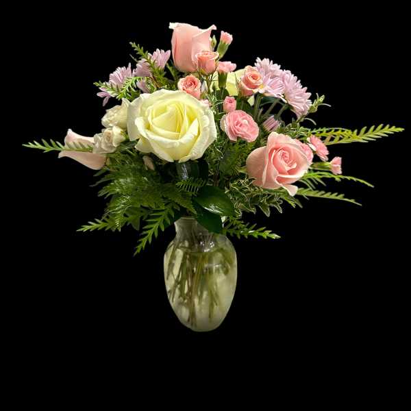 Pink and white rose bouquet in a clear glass vase