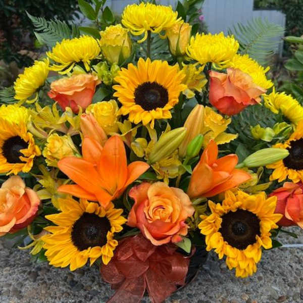 Sunflower and orange lily bouquet with peach roses in a vase