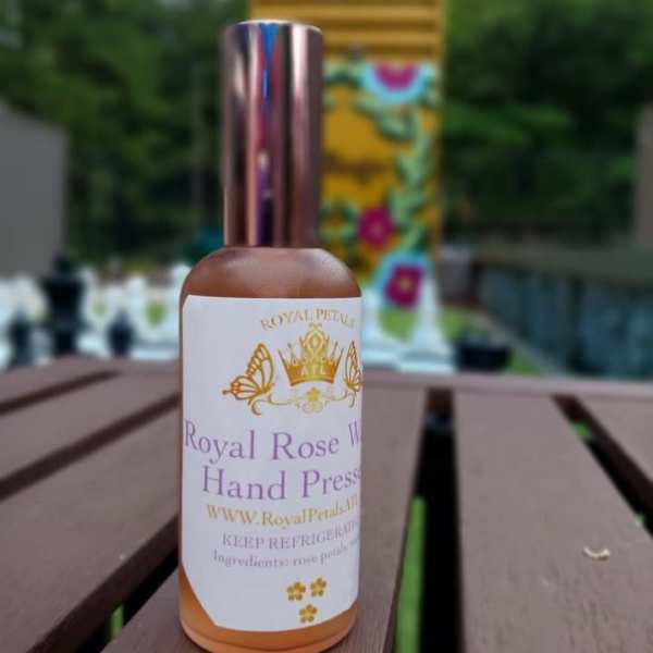 Bottle of rose water with a gold cap on a table