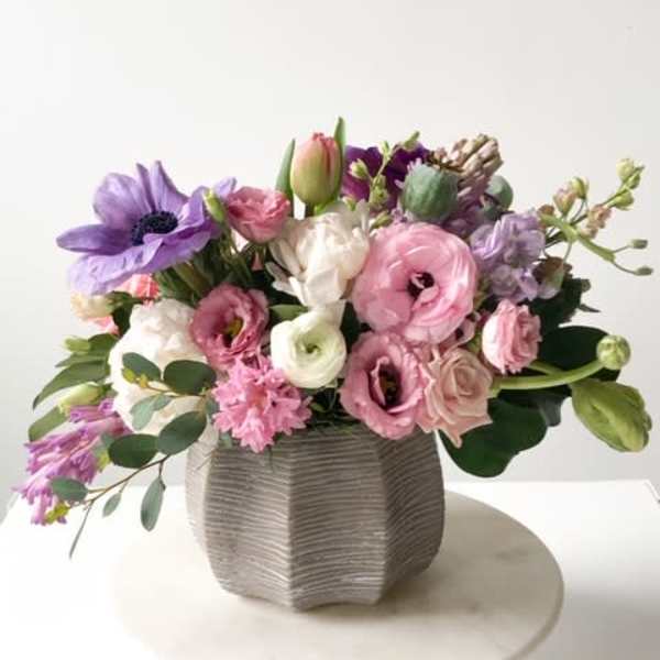 Pink and purple mixed bouquet in a textured gray vase
