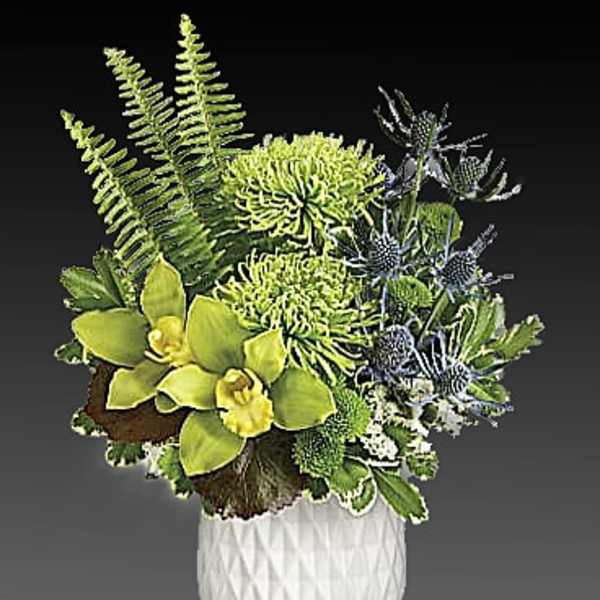 Green and blue floral arrangement in a white textured vase