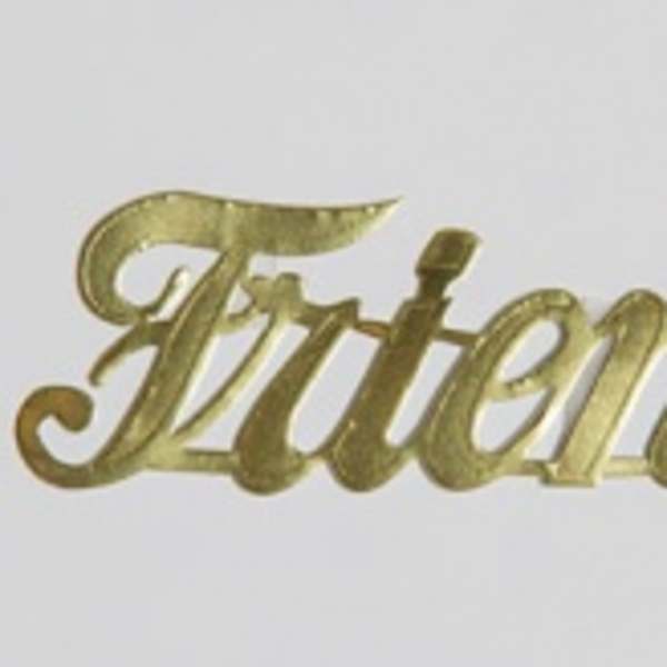 Gold script sign reading "Friends" on a white background