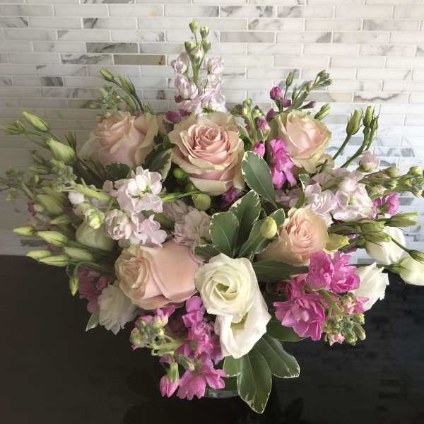 Bouquet of blush and white roses with pink flowers in a vase