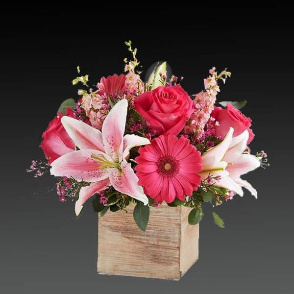 Pink roses and lilies arranged in a wooden box