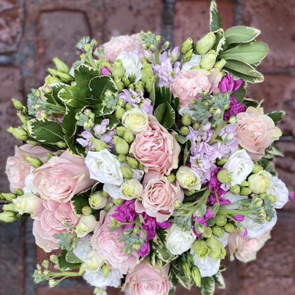 Round bouquet of pink and white roses with lavender flowers