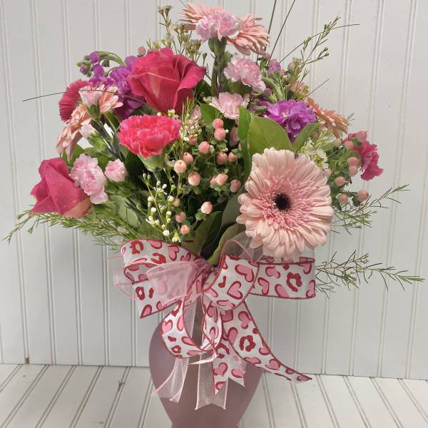 Pink mixed bouquet in a vase with a heart-patterned ribbon