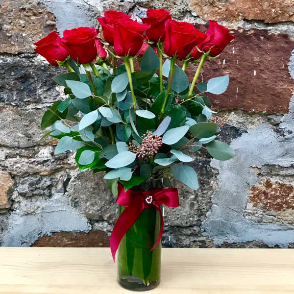 Red roses in a glass vase with a red ribbon