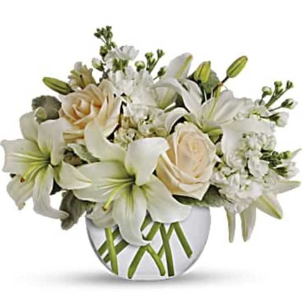 White lilies and cream roses in a round glass vase