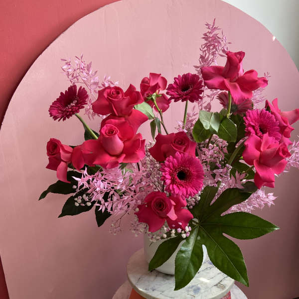 Pink rose and gerbera daisy arrangement in a white vase