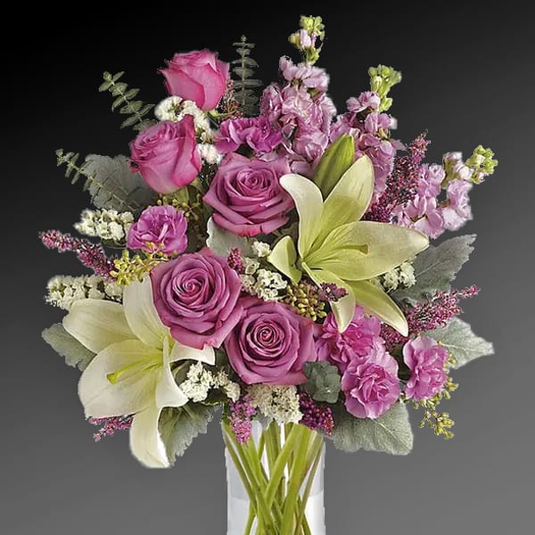 Pink roses and white lilies in a clear glass vase