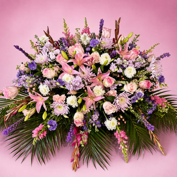 Large pink and purple floral arrangement with lilies, roses, and chrysanthemums