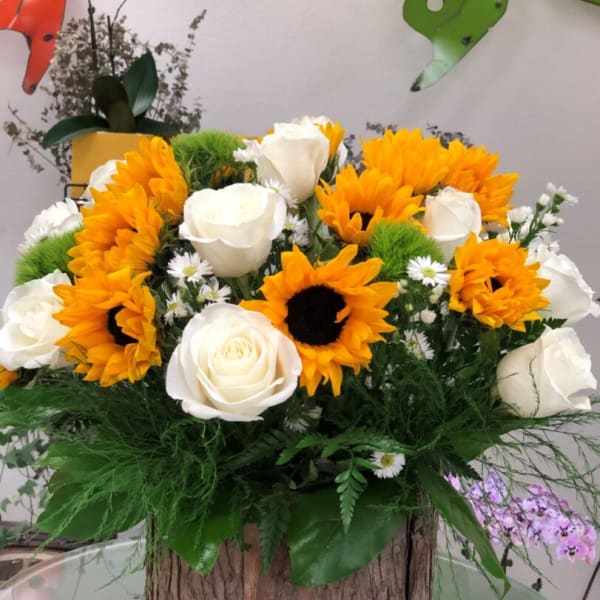 Sunflower and white rose arrangement in a rustic wooden container