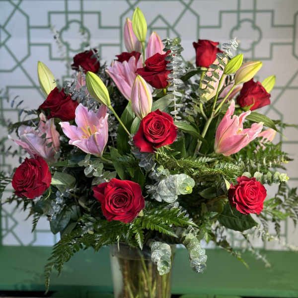 Red roses and pink lilies in a clear glass vase