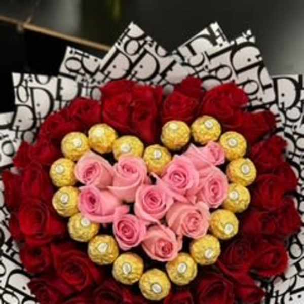 Heart-shaped bouquet of red and pink roses with gold chocolates