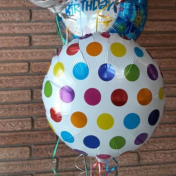 Cluster of birthday balloons with colorful polka dots and emoji designs