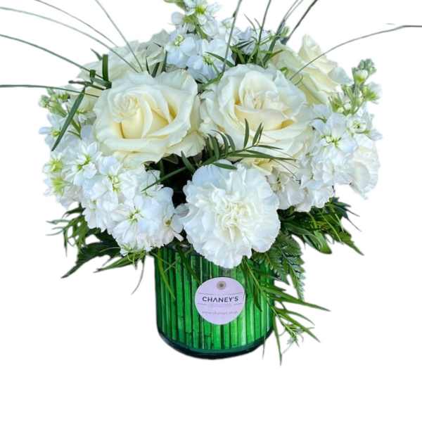 White roses and carnations in a green glass vase