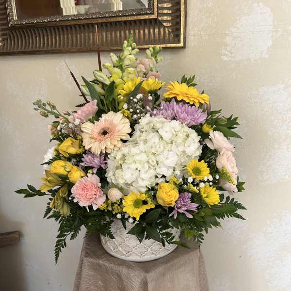 Mixed pastel flower arrangement in a white ceramic vase