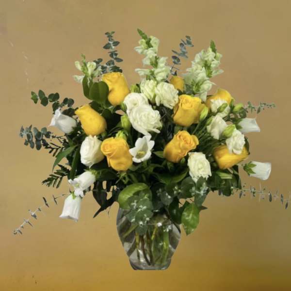 Yellow and white roses in a clear glass vase