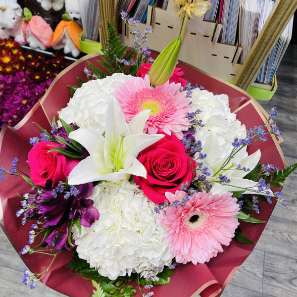 Bouquet of pink roses, white lilies, and pink gerbera daisies