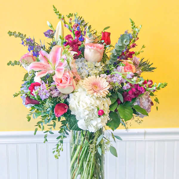 Mixed bouquet in a clear glass vase with pink, white, and purple flowers