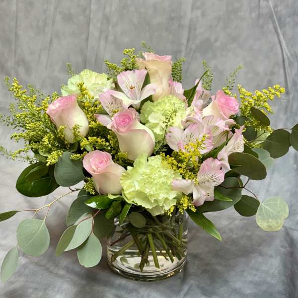 Pink roses and pale green carnations in a glass vase