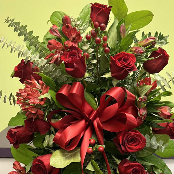 Red rose and alstroemeria arrangement with a large red ribbon