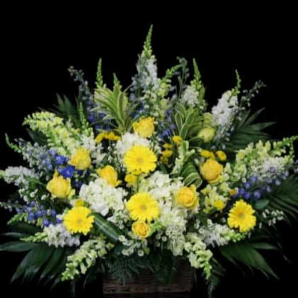 Large yellow and white floral arrangement in a basket