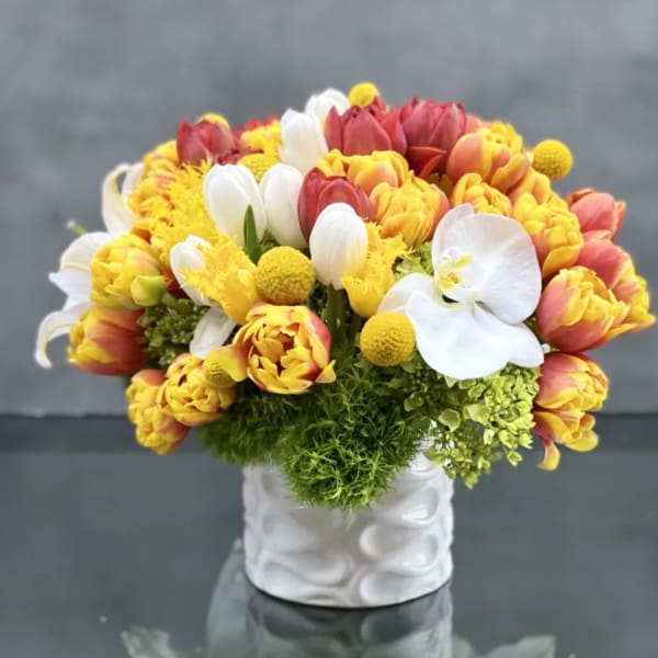 Bouquet of yellow, red, and white tulips in a white vase