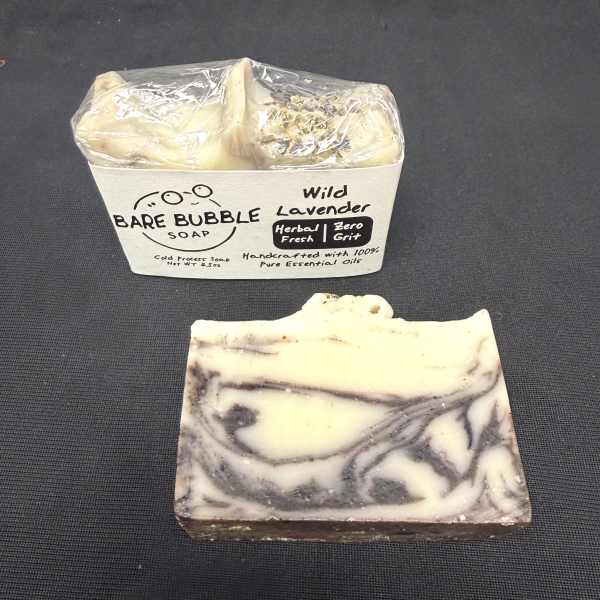 Bar of lavender soap beside a packaged soap container