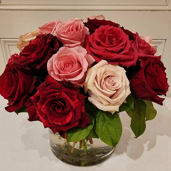 Bouquet of red and pink roses in a clear glass vase
