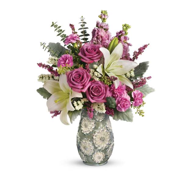 Pink roses and white lilies in a decorative glass vase
