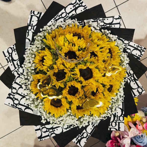 Bouquet of yellow sunflowers with white baby's breath and black patterned wrap