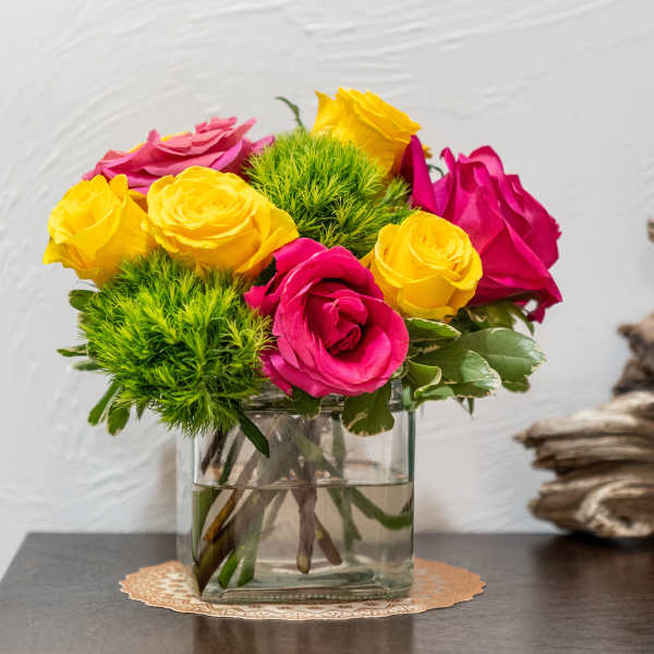 Pink and yellow roses in a clear glass vase