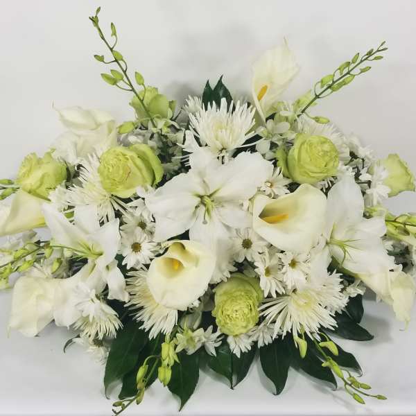 White calla lilies and green blooms in a low floral arrangement