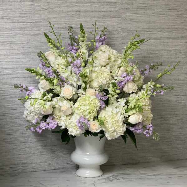 White and lavender floral arrangement in a white vase