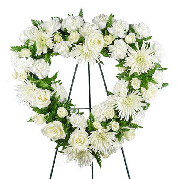 White floral wreath on a black easel stand