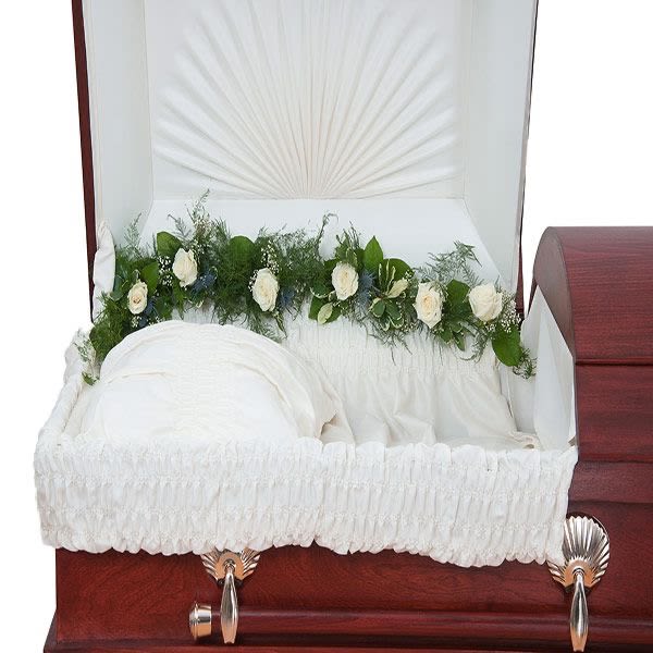 White rose garland lining the interior side of an open wood casket