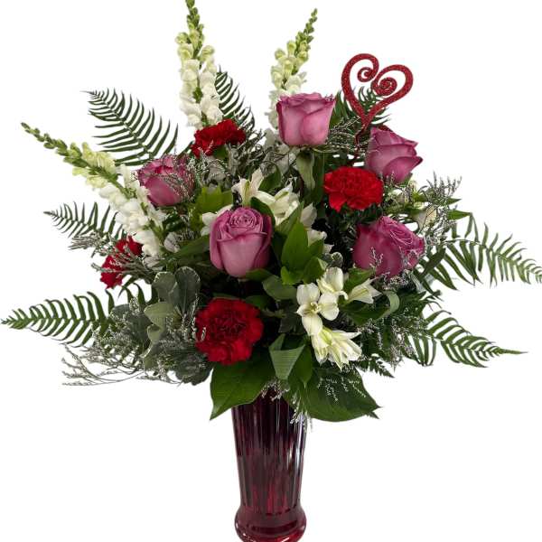 Pink roses and red carnations in a tall burgundy vase with a glitter heart pick