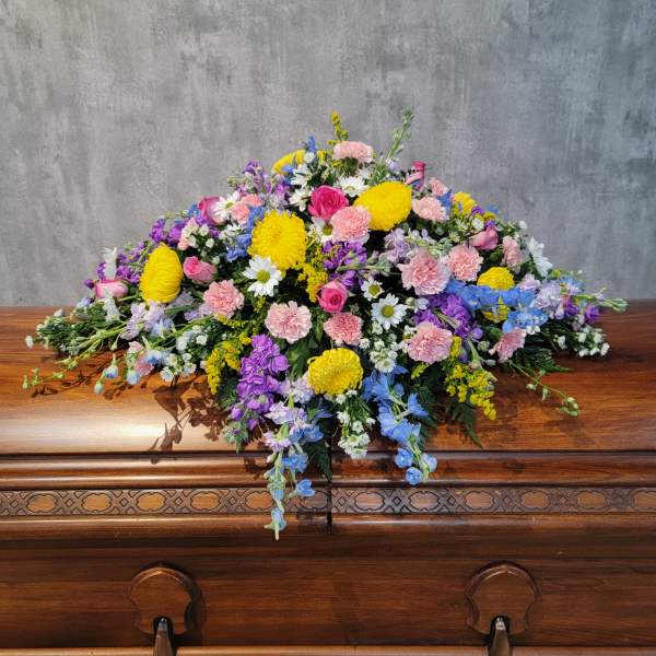 Colorful floral spray on a wooden casket