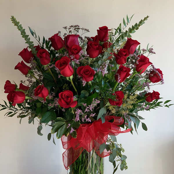 Bouquet of red roses in a glass vase with a red ribbon