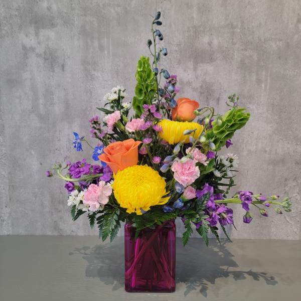 Colorful mixed bouquet in a purple glass vase