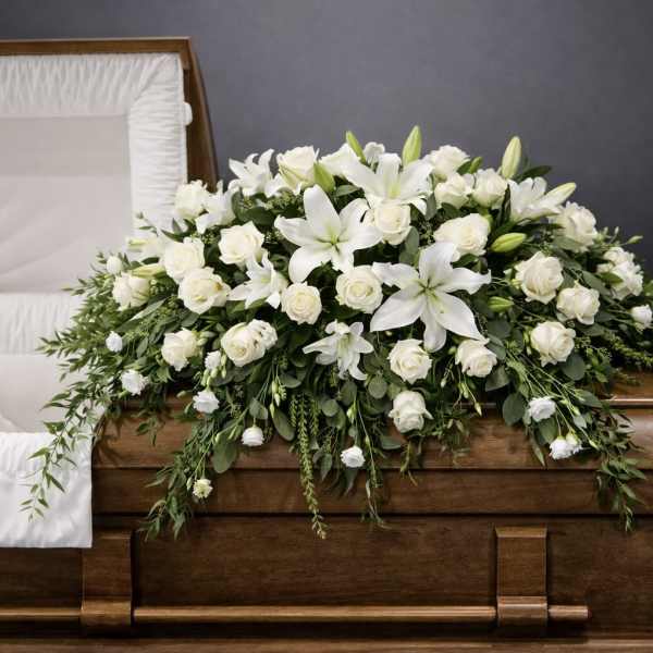White floral casket spray with lilies and roses