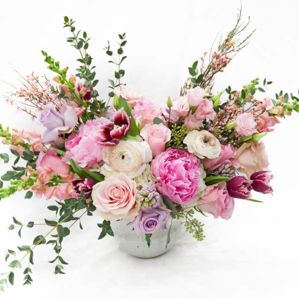 Pink and lavender floral arrangement in a white vase