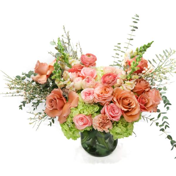 Peach and pink rose arrangement in a dark glass vase