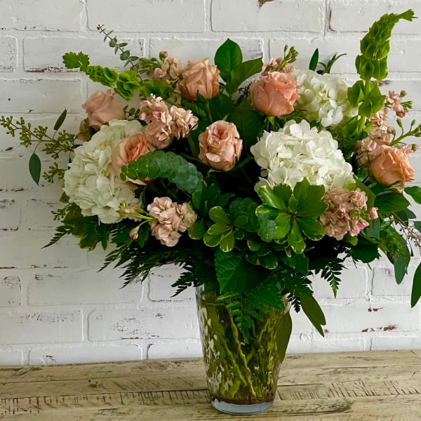 Peach roses and white hydrangeas in a glass vase