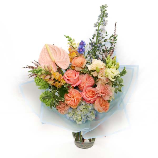 Pastel bouquet with roses, hydrangea, and anthurium in a glass vase