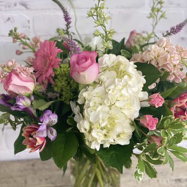 Mixed pink and white flowers in a clear glass vase